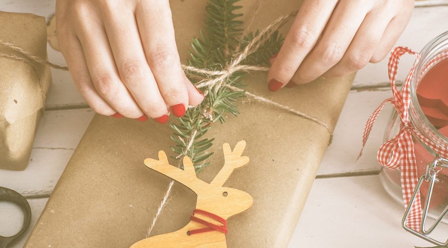 woman tying bow on holiday package